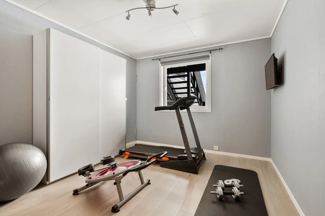 Modern home gym in a finished basement with treadmill and exercise equipment