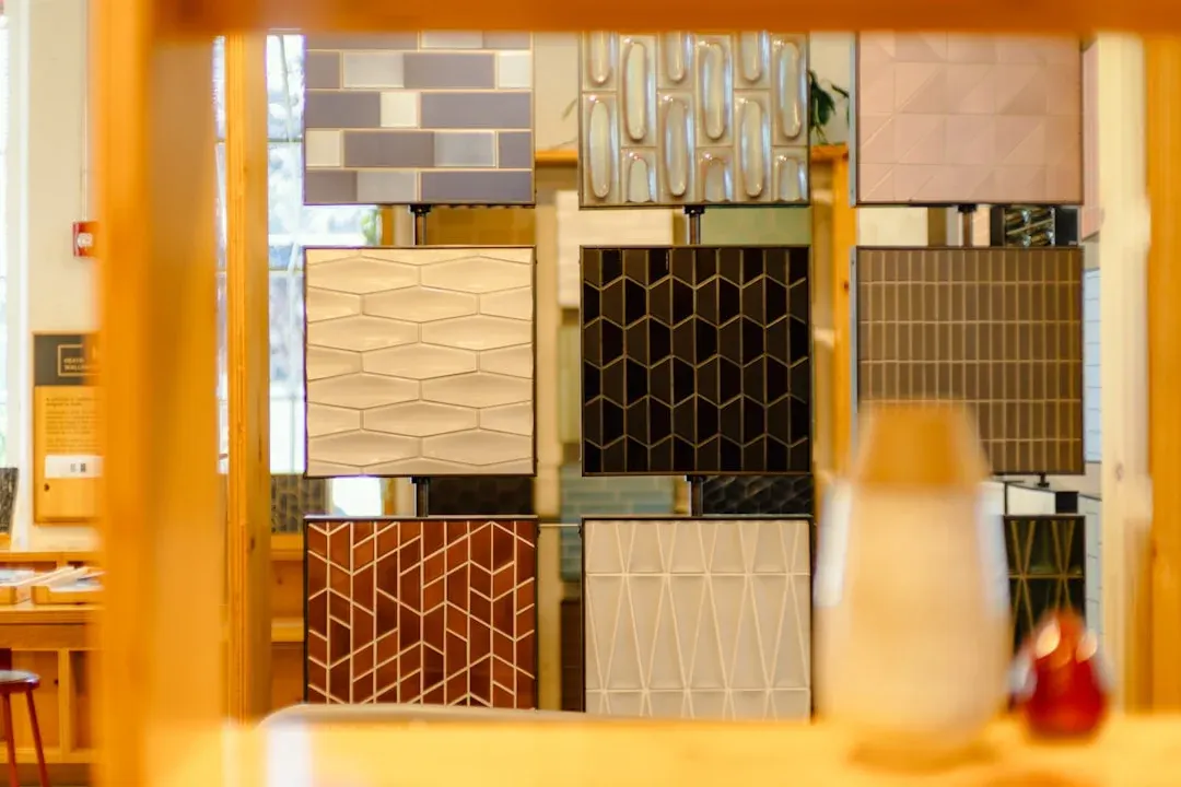 Mur d'échantillons de carreaux aux motifs et textures variés dans un showroom