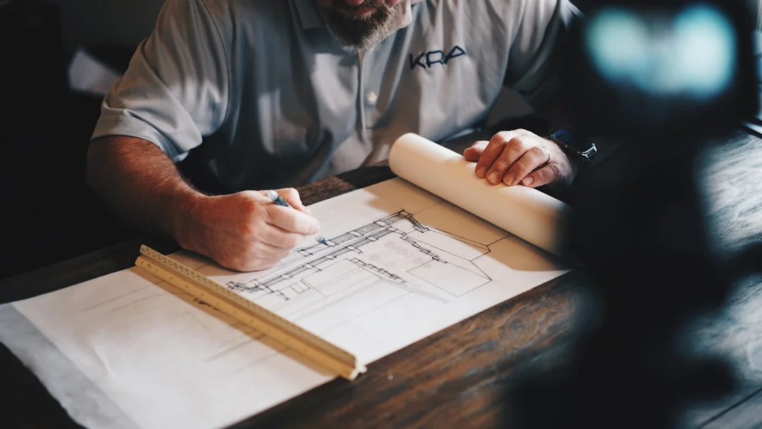 Entrepreneur qui examine des plans architecturaux sur une table de travail