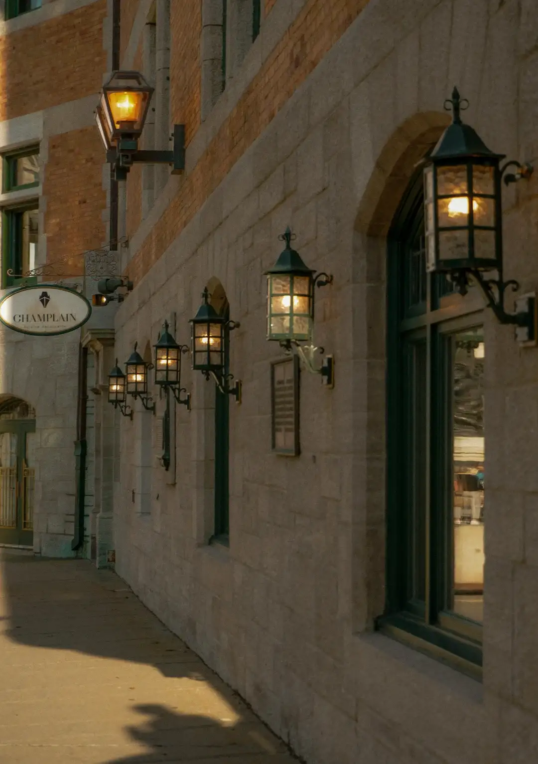 Heritage stone facade in Old Quebec with cast iron lanterns, historic lime mortar masonry