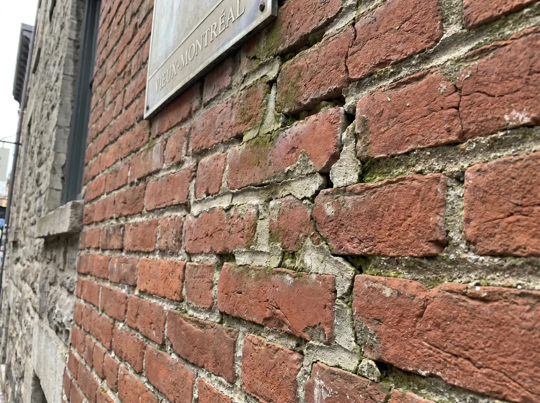 Mur de brique avec joints de mortier effrités et fissure verticale