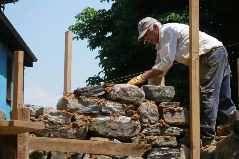 Craftsman repairing ancient brick masonry structure outdoors