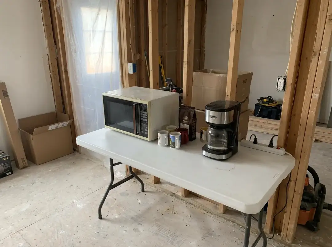 Temporary makeshift kitchen with microwave and coffee maker on a folding table